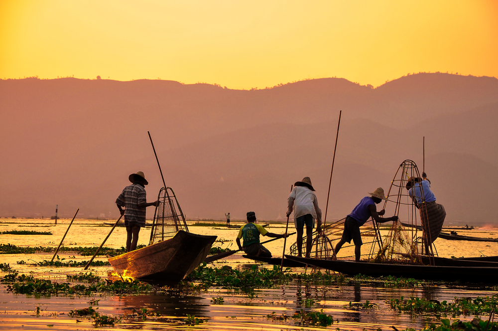 Pescadores al atardecer en un lago de Asia